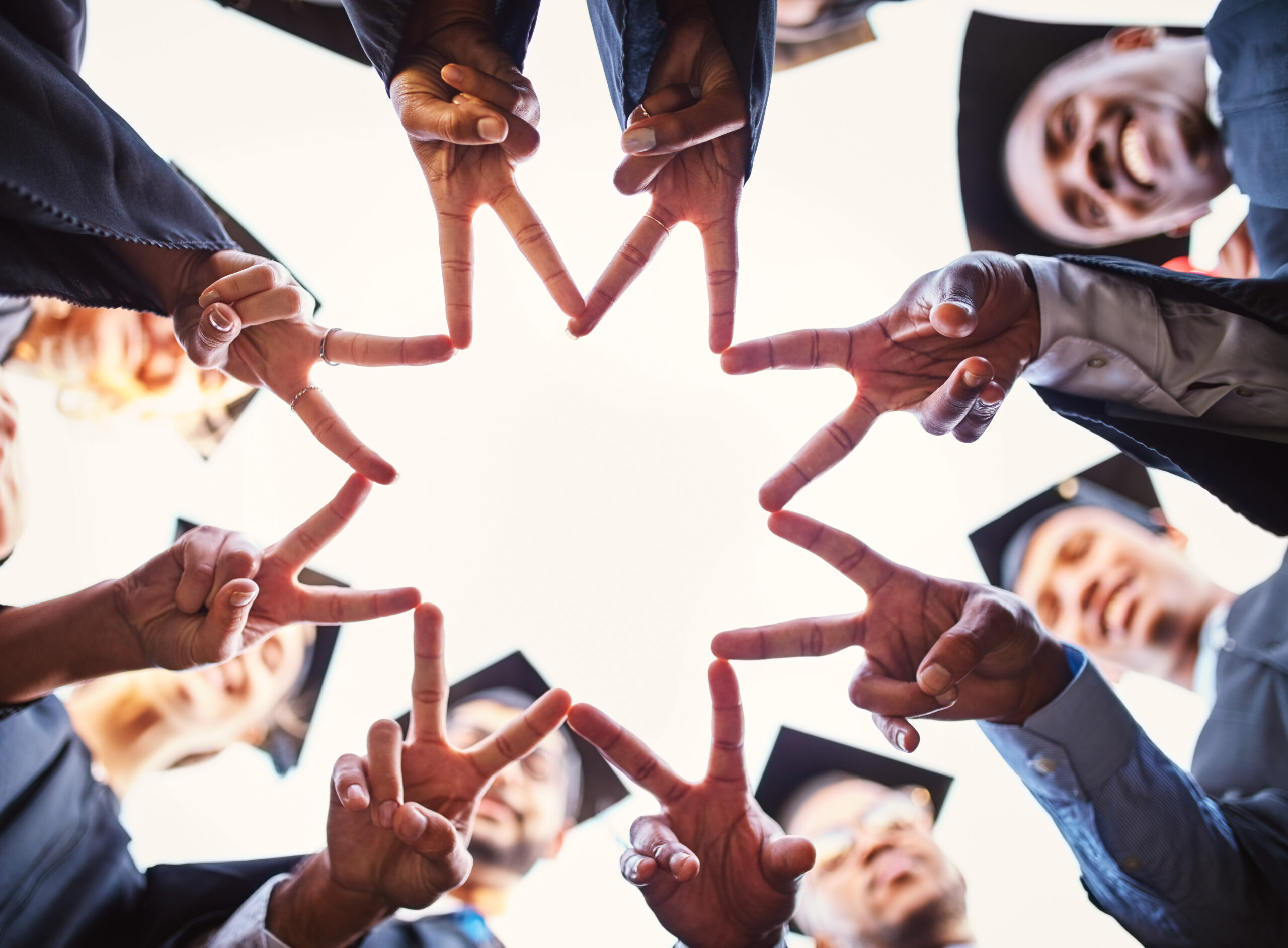 People putting their hands together to make a star