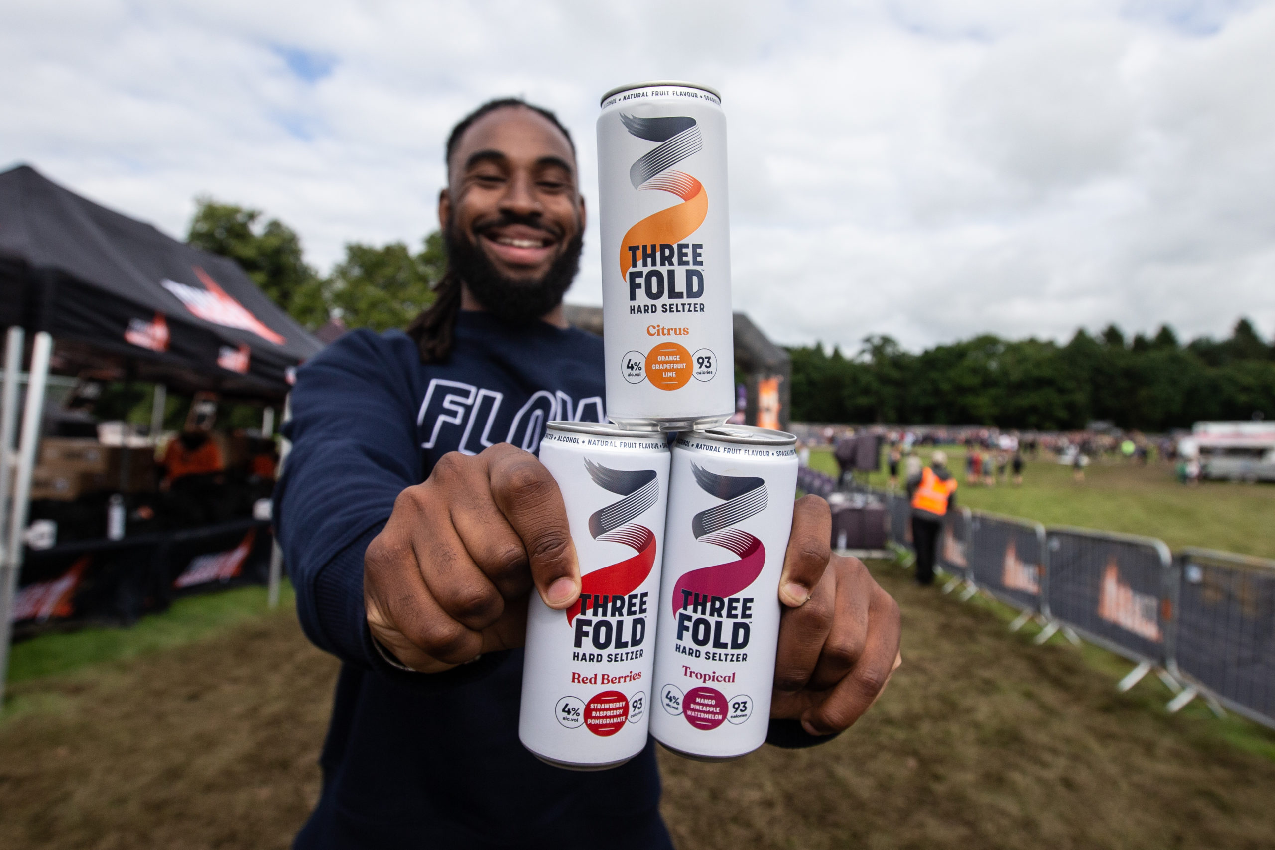 tough mudder- someone holding cans of Three Folds